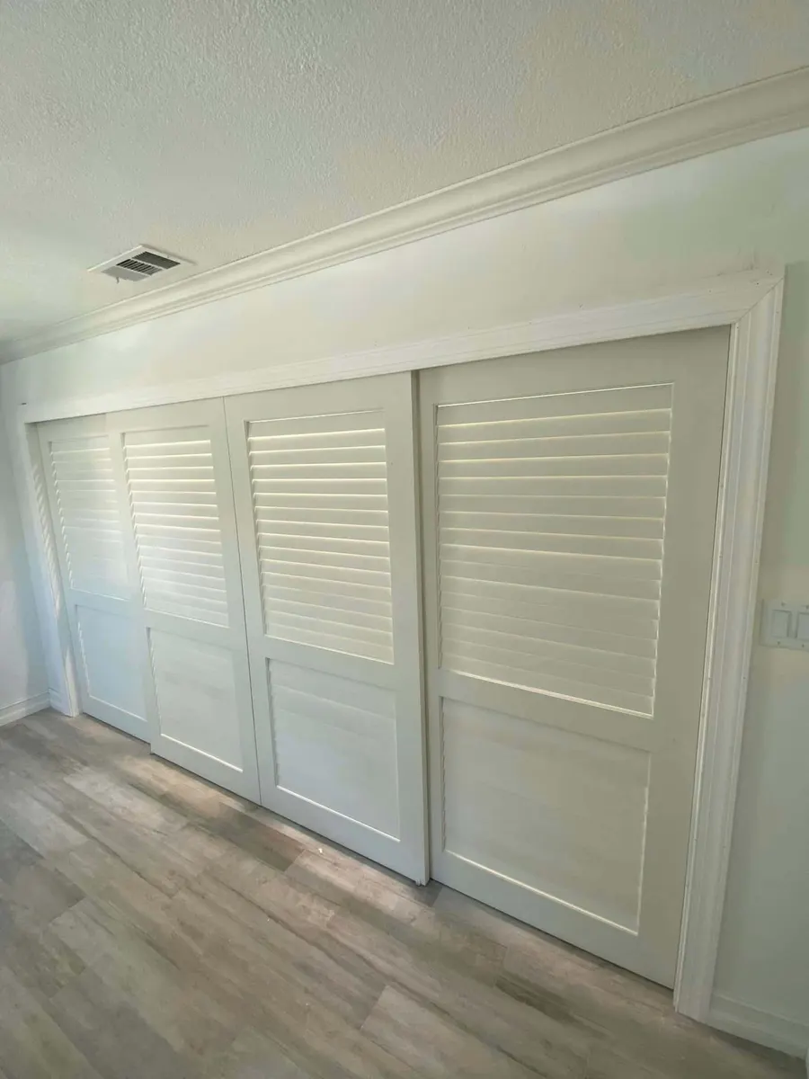 White louvered sliding closet doors with crown molding
